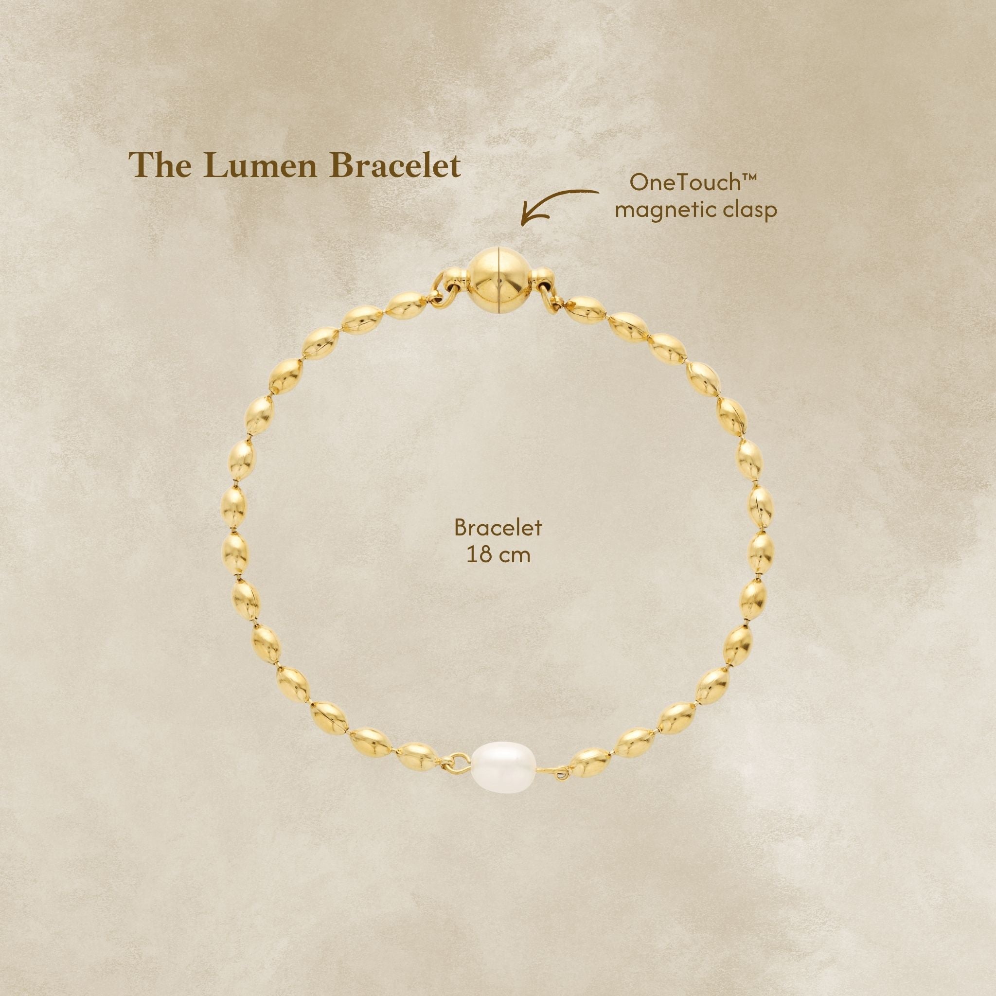 Gold bracelet with pearl accent on a beige background