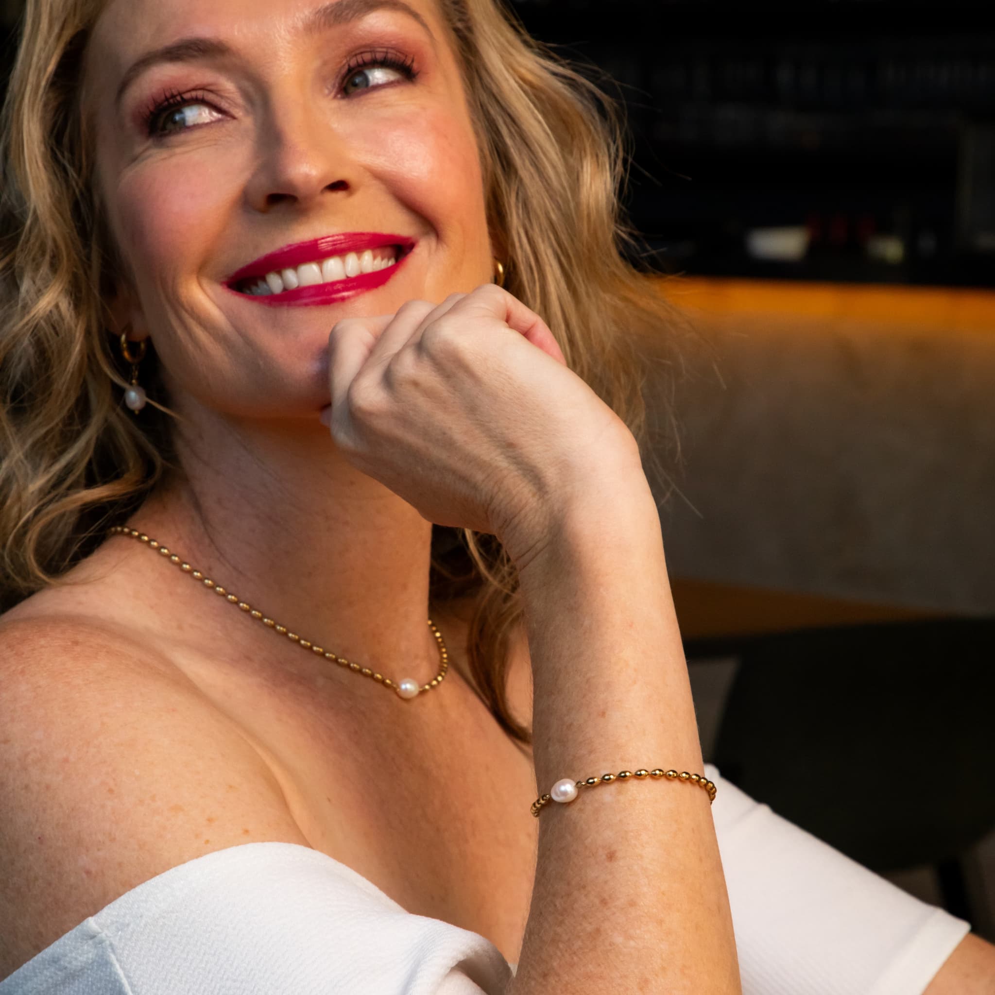 Woman wearing The Lumen single pearl on chain necklace and bracelet by Avean Jewellery
